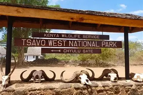 Entrance sign to Tsavo West National Park at Chyulu Gate with buffalo skulls framing the welcome